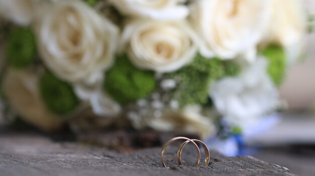 Anneaux de mariage et bouquet de mariage sur une planche en bois