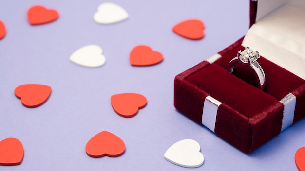 Anneaux de mariage dans une boîte cadeau avec des coeurs sur fond violet