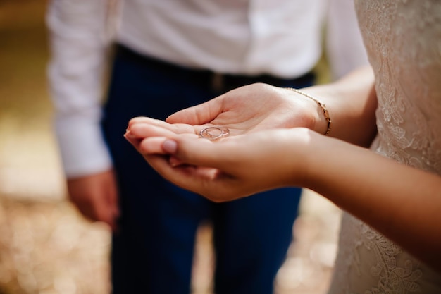 Anneaux de mariage dans la macro des mains de la mariée