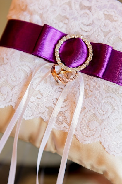 Photo anneaux de mariage sur dentelle blanche et ruban violet