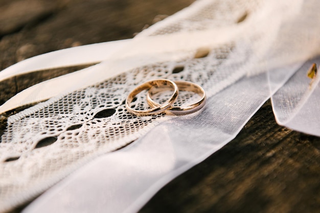 Anneaux de mariage sur le fond des rubans de dentelle