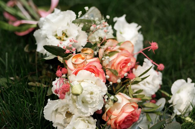 Anneaux de mariage sur le gros plan du bouquet de la mariée