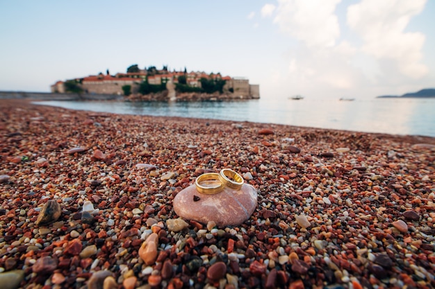 Anneaux de mariage de jeunes mariés sur des galets de plage