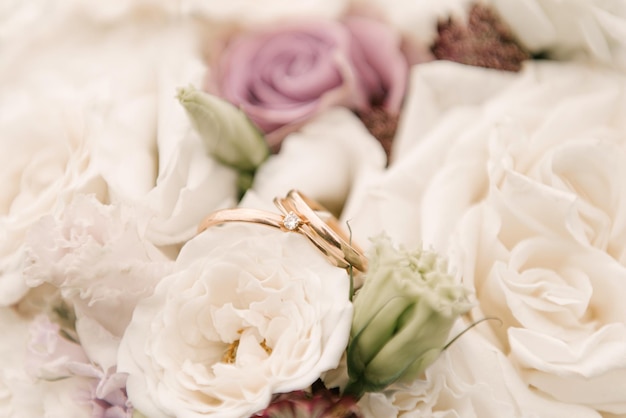 Anneaux de mariage de mariage sur un bouquet de fleurs soft focus