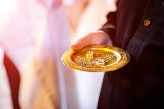 Anneaux de mariage d'or sur le plat d'or dans l'église