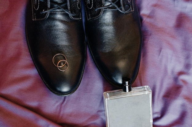 les anneaux de mariage reposent sur des chaussures pour hommes noirs