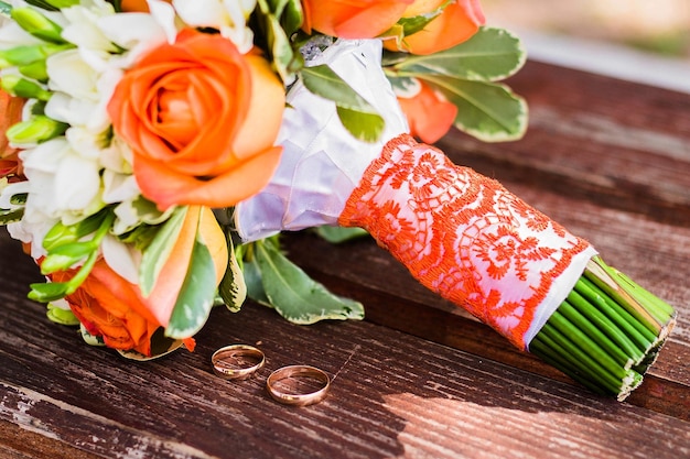 Les anneaux de mariage se trouvent et le beau bouquet