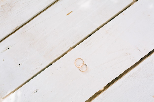 Anneaux de mariage sur une texture en bois blanc