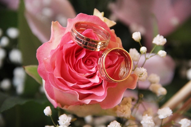 Anneaux d'or de mariage avec bouquet de fleurs de mariée