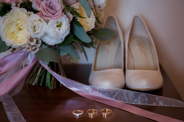 Anneaux d'or de mariage avec un bouquet de la jeune mariée