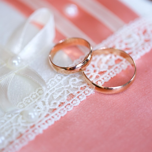 Anneaux d'or de mariage mariée et le marié sur un oreiller décoratif.