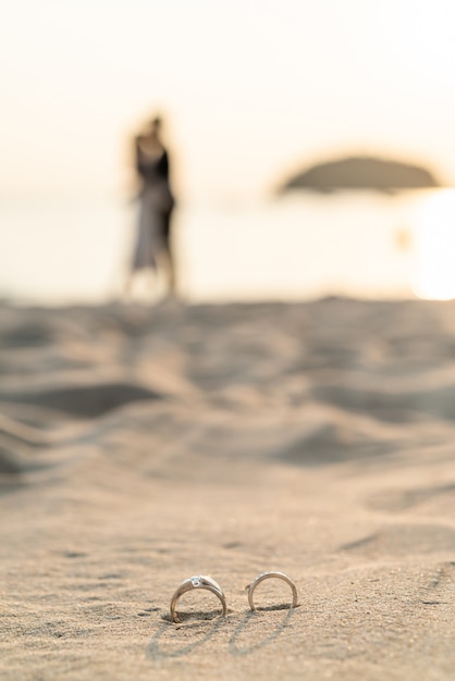 Photo anneaux sur la plage avec la mariée et le marié