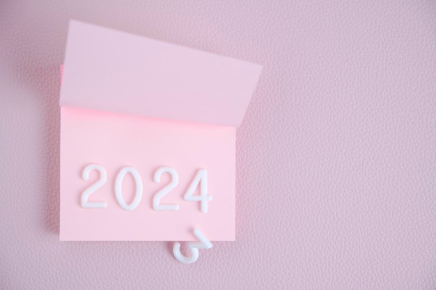 L'année 2024 est disposée en chiffres blancs feuille roseConcept temps et nouvelle année