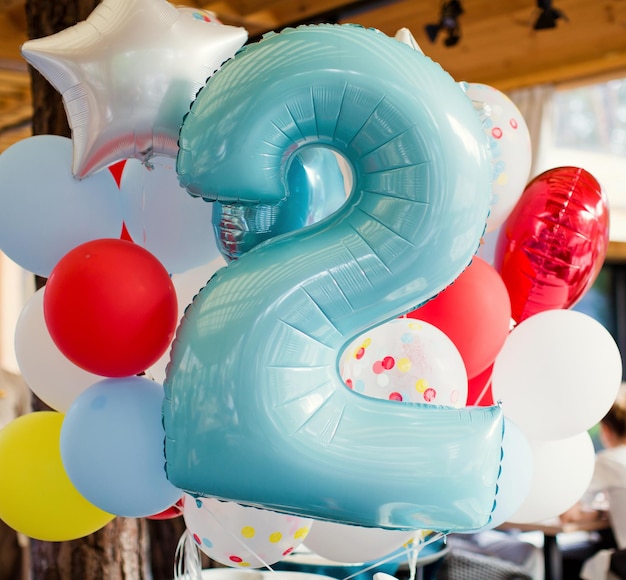 Anniversaire ballons blancs jaunes rouges et transparents avec des confettis et ballon numéro deux Fête avec des décorations de ballons