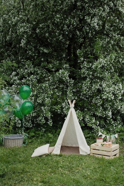 Anniversaire d'été, décoration dans le jardin. Wigwam et gâteau.