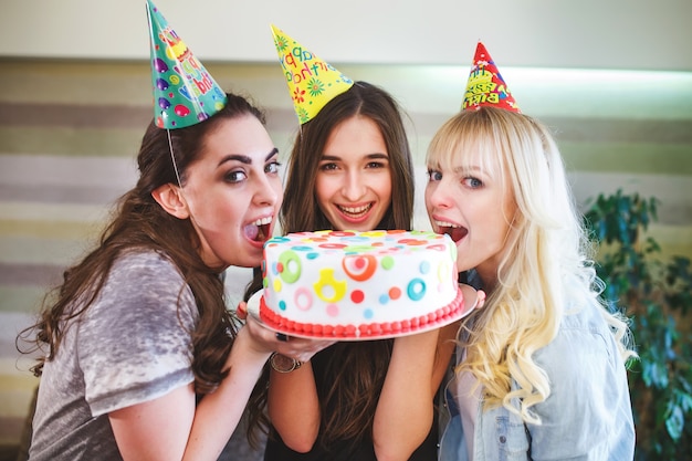 Anniversaire. Filles mordre le gâteau lors d'une fête d'anniversaire.