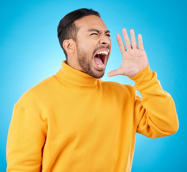 Annonce main et jeune homme isolé sur fond bleu pour la vente de bourses d'études ou la diffusion universitaire Crier la voix et l'opinion d'une personne ou d'un étudiant avec des nouvelles du collège ou de l'attention en studio