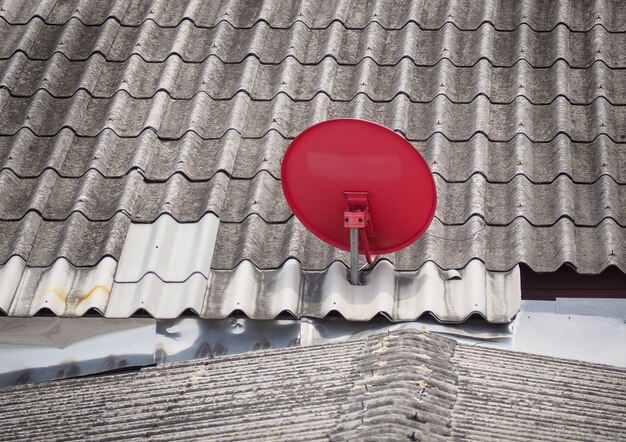 Une antenne parabolique rouge est fixée sur le toit. Bangkok, Thaïlande.