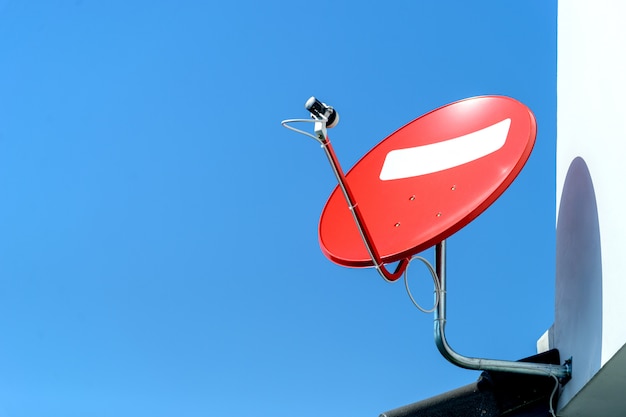 Antenne satellite rouge avec ciel bleu