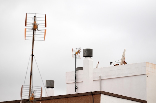 Antennes sur un toit au-dessus d'un ciel nuageux