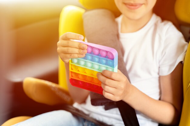 anti stress sensoriel pop it jouets dans les mains d'un enfant une petite fille joue avec un jouet dans la voiture