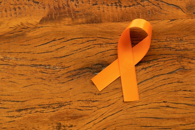 Photo août orange campagne de sensibilisation à la sclérose en plaquesruban orange sur table en bois