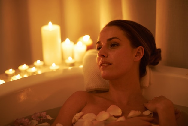 Apaisé par l'ambiance et un bain chaud Photo recadrée d'une femme magnifique se relaxant dans un bain aux chandelles