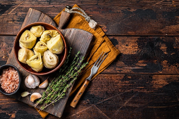 Apéritif Coeurs d'artichauts marinés à l'huile d'olive avec des herbes et des épices Fond en bois Vue de dessus Espace de copie