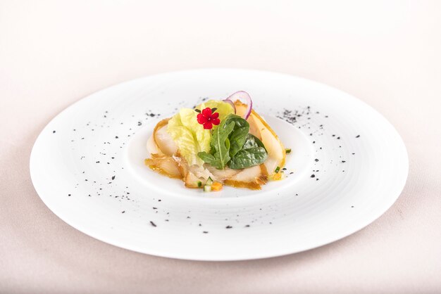 Apéritif frais avec poisson blanc fumé, rucola, pousses d’épinards et salade verte, avec fleurs rouges