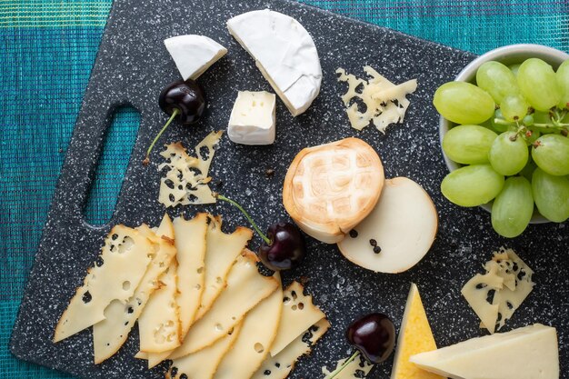 Apéritif froid Charcuterie Fromage sur planche à découper isolé sur fond bleu vue de dessus