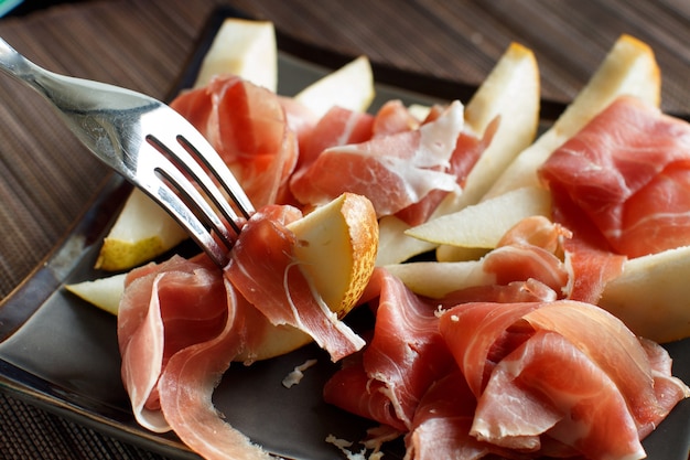 Apéritif avec poire et jambon de parme italien close up