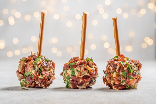 Photo des apéritifs de fromage de noël avec du bacon, des noix de pécan et des herbes