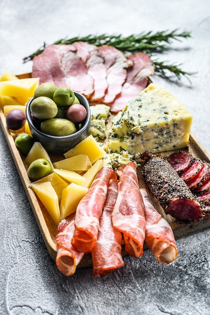 Apéritifs italiens ou antipasti set épicerie fine mixte de fromages et de collations à la viande. Fond gris. Vue de dessus