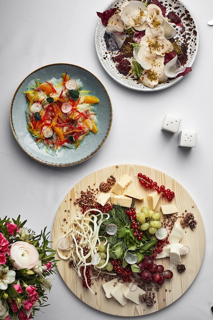 Apéritifs sur la vue de dessus de table fromages assortis vitello tonnato ceviche de poisson fond clair collations italiennes