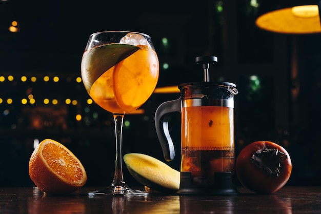 Photo aperol spritz et thé à la mangue dans la presse française sur fond de bois foncé