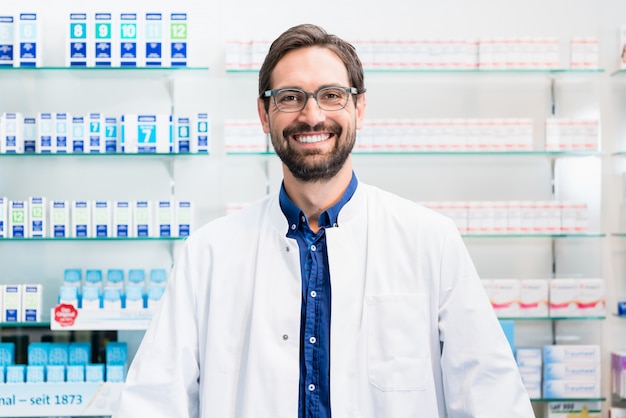 Apothicaire en pharmacie debout sur une étagère avec des médicaments