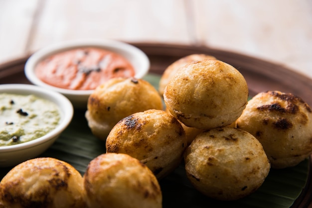 Appam ou Mixed dal ou Rava Appe servi sur fond de mauvaise humeur avec chutney vert et rouge. Une recette de petit-déjeuner populaire en forme de boule dans le sud de l'Inde. Mise au point sélective