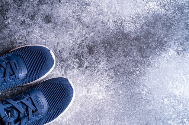 Appareil de fitness avec des baskets sur fond gris, vue de dessus. Copiez l'espace pour le texte.