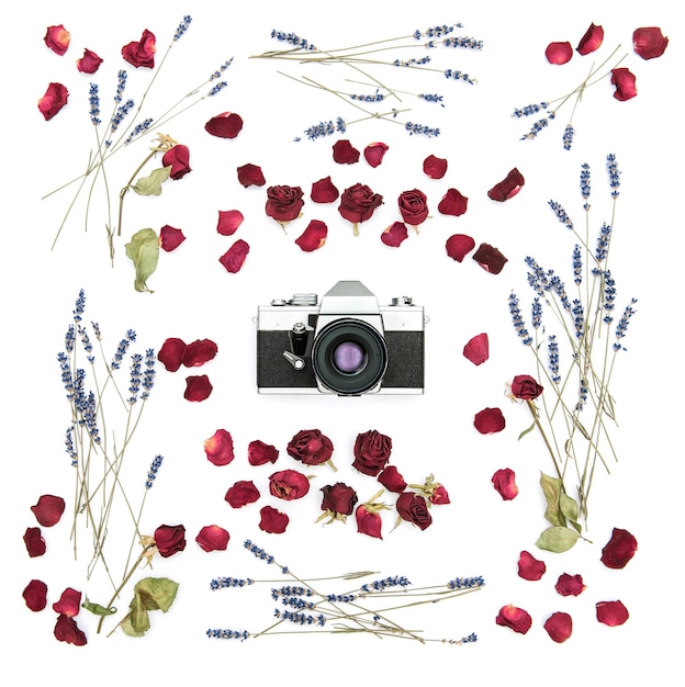 Appareil photo argentique d'époque. Cadre floral avec des roses et des fleurs de lavande. Fond plat. Plantes séchées