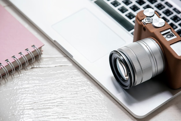 Appareil photo classique mis sur ordinateur portable sur la table blanche