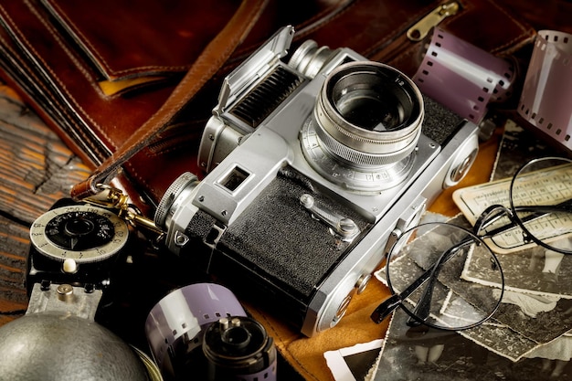 Photo un appareil photo avec un étui en cuir marron et des lunettes dessus.