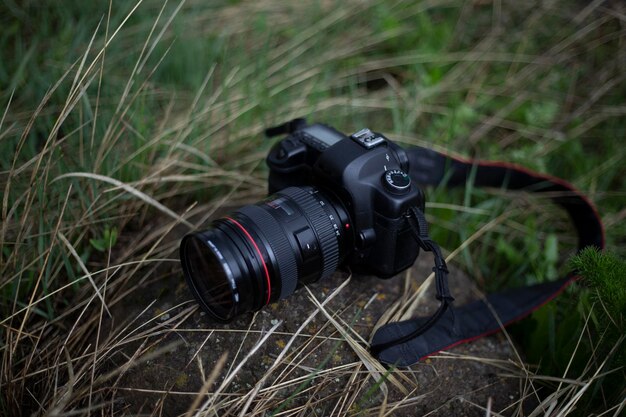 Un appareil photo numérique noir se trouve sur l'herbe