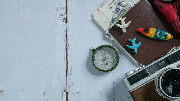 L'appareil photo et le passeport sur table en bois pour le concept de voyage.