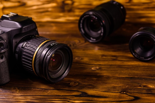 Appareil photo reflex numérique moderne et objectifs sur une table en bois rustique