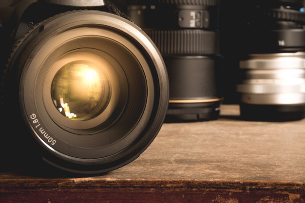 Appareil photo reflex numérique noir avec objectif principal de 50 mm 1,8 G sur une vieille surface de boîte vintage en bois brun