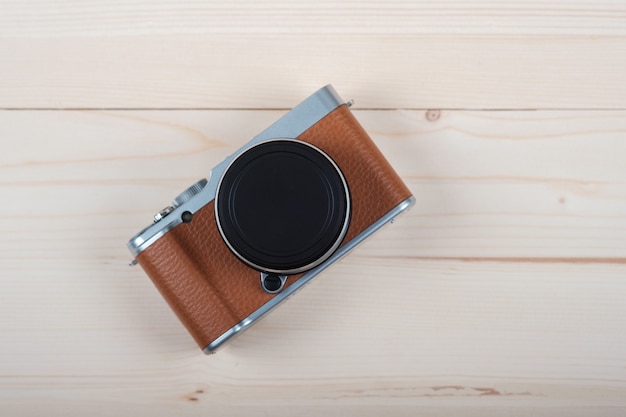 Appareil photo sans miroir moderne et élégant de couleur marron sur une planche en bois clair