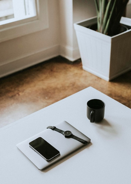 Appareils numériques par une tasse de café sur un bureau