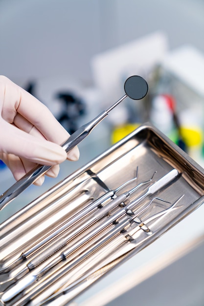 Photo appareils de stomatologie en acier inoxydable dans les mains matériel médical dentaire