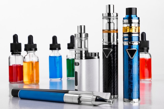 Appareils de vapotage et bouteilles de liquide vape sur fond blanc