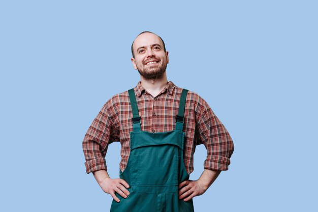 Apparence professionnelle d'un travailleur gai barbu avec les bras sur les hanches avec un large sourire sur leur